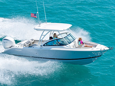 A starboard side exterior view of family fun on a D 246 Pursuit Denali dual consloe Boat running offshore.