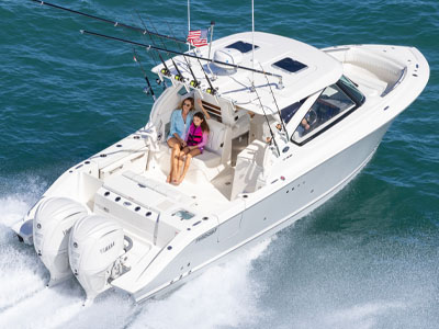 Pursuit D 306 Denali dual consloe running offshore with mother and daughter seated in the bridge deck social zone.