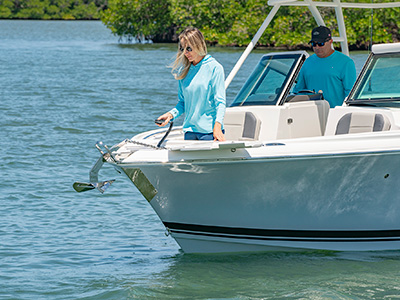 A woman drops an anchor on a 25’ D 246 Pursuit Luxury Dual Console boat.
