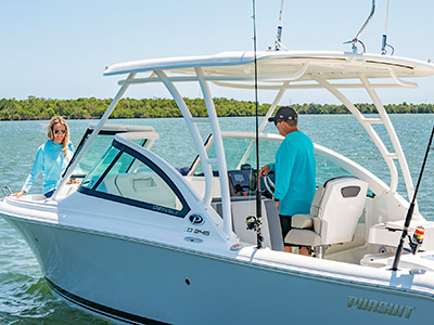 A couple enjoys a day on the water ready to fish or cruise on a 25’ D 246 Pursuit Luxury Dual Console boat.
