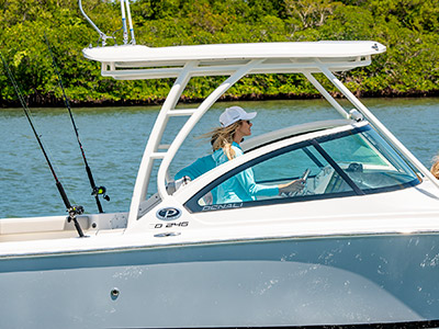 A woman is cruising at the helm of a D 246 Pursuit Luxury Dual Console boat.