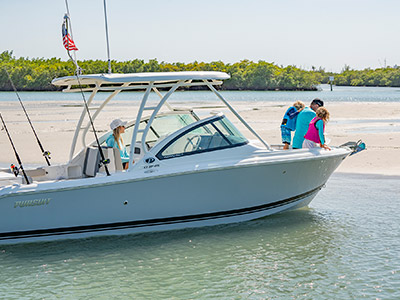 A family is enjoying a day at the sandbar on a new D 246 Pursuit Luxury Dual Console boat.