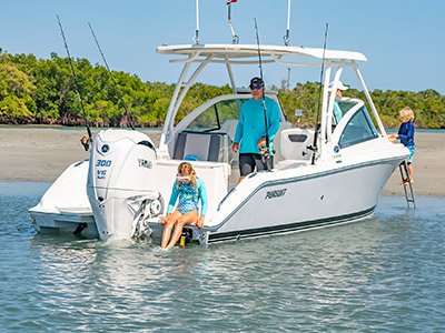 A family plays on a sandbar on a 25’ D 246 Pursuit Luxury Dual Console boat.