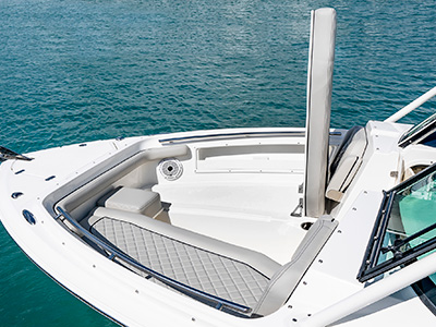 A view of forward lounge seating open on the 25’ D 246 Pursuit Luxury Dual Console Boat to reveal insolated storage.