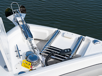 A windlass anchor system with remote next to a stowed beach boarding ladder on a new D 246 Pursuit Luxury Dual Console Boat.