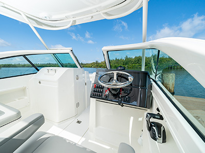 The helm of a D 246 Pursuit Luxury Dual Console boat covered by an integrated fiberglass hardtop.