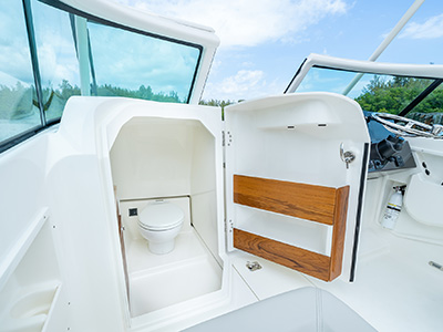 The port side head with an open door on a 25’ D 246 Pursuit Luxury Dual Console boat.