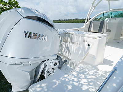 A large swim platform extends from the transom door on a D 246 Pursuit Luxury Dual Console boat.