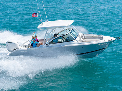 A starboard side exterior view of family fun on a D 246 Pursuit Luxury Dual Console Boat running offshore.