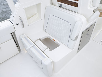 Overhead view of aft facing seat with bench flipped open showing stowage on Pursuit Boats D 286 Dual Console.
