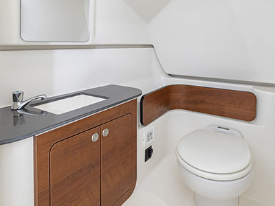 Enclosed head space with teak accents on the Pursuit D 286 boat.