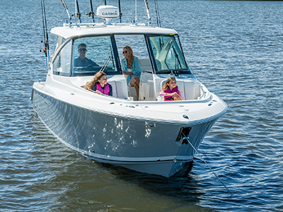 A family enjoys relaxing on a Pursuit D 306 Luxury Dual Console boat.