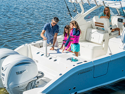 A man adjusts a ski pole on a Pursuit D 306 Luxury Dual Console boat.
