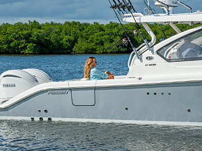 A woman relaxes in the stern on a Pursuit D 306 Luxury Dual Console boat.