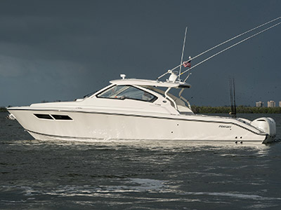 Side view of white Pursuit D 365 luxury dual console boat on over cast day.