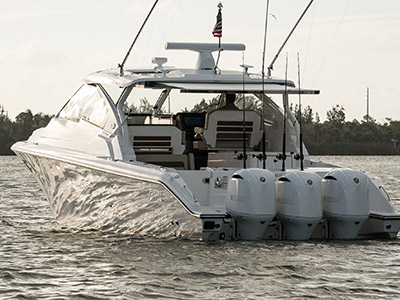 Rear view of white Pursuit D 365 luxury dual console boat on over cast day.