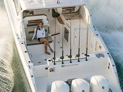 Aerial close up view of cockpit on a D 365 luxury dual console boat one of our cabin cruiser fishing boats. Female sitting on rear facing seat.