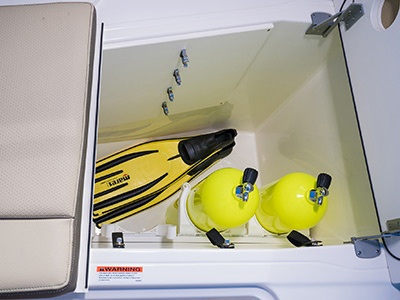 Pursuit D 365 luxury dual console boat under seat bow storage with dive gear.
