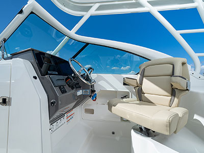 Bridge view of helm and helm seat of Pursuit DC 266 dual console boat.