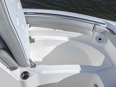 A view of forward lounge seating open on the DC 266 Pursuit Luxury Dual Console Boat to reveal insolated storage.