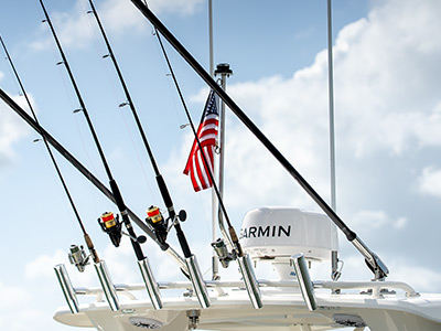 Rod holders & rods next to American flag on a 28’ Dual Console by Pursuit.