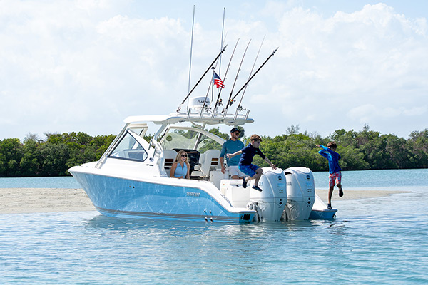 Boys jumping into the water from the extended transom platforms of the Pursuit DC 286.