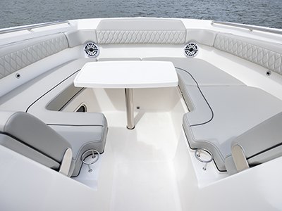 Pursuit DC 365 luxury dual console boat bow social zone with table.