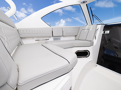 Detail view of OS 355 offshore boat Molded Port Bridge Lounge Seating with Large Backrest, Folding Arm, Molded Footrest and Port Articulating Armrest.