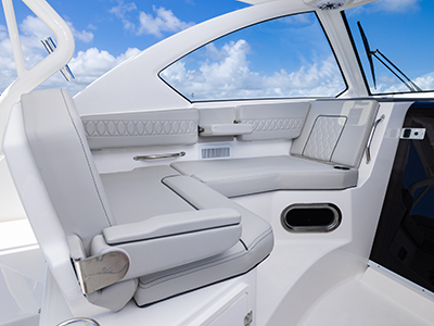 Detail view of OS 355 offshore boat Molded Port Bridge Lounge Seating with Large Backrest, Folding Arm, Molded Footrest and Port Articulating Armrest.