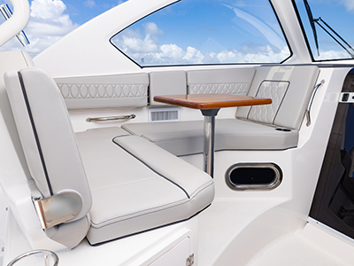 Detail view of OS 355 offshore boat Molded Port Bridge Lounge Seating with Large Backrest, Folding Arm, Molded Footrest, Table and Port Articulating Armrest.