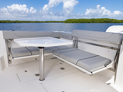 Detail view of OS 355 offshore boat folding transom seating with Fiberglass Cockpit Table.