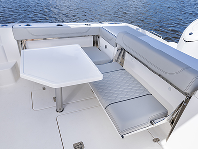 Detail view of OS 355 offshore boat folding transom seating with Fiberglass Cockpit Table.