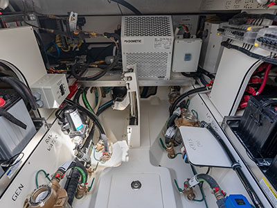 Machinery space of a Pursuit OS 445 showing batteries, pumps, and wiring runs.