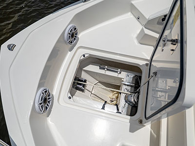 Open console-side compartment on a Pursuit OS 445 showing storage and speakers.