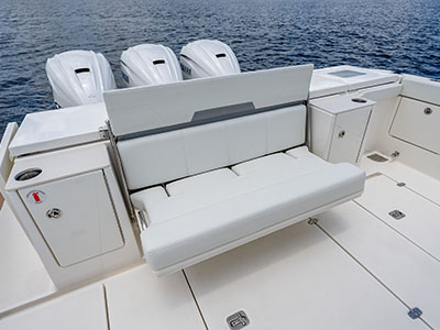 Aft bench seat deployed in the cockpit of a Pursuit OS 445, outboards behind.
