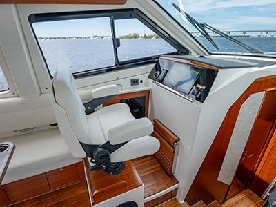 Helm seat and electronics aboard a Pursuit OS 445 with teak cabinetry.