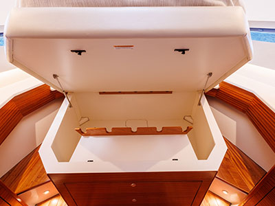Berth lifted to show the storage compartment beneath, aboard a Pursuit OS 445.