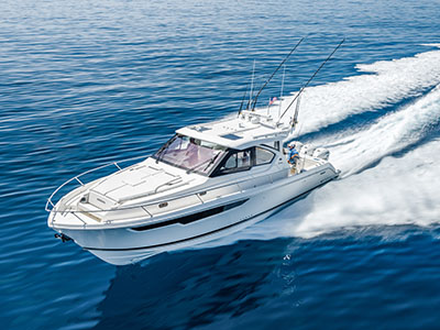 Pursuit OS 445 running on open blue water, port profile, outriggers rigged and hardtop up.