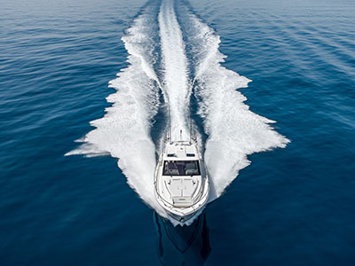 Pursuit OS 445 running head-on toward the camera, throwing a wide V of spray.