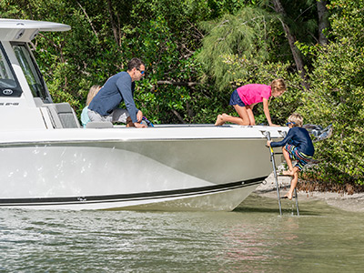 Kids using beach boarding ladder on Pursuit Boats S 248 Sport Center Console Boat.
