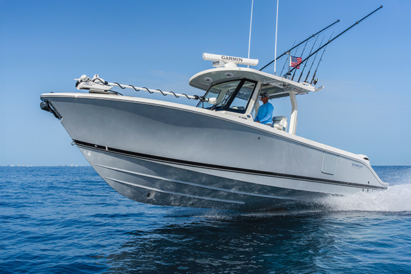 Pursuit C 288 center console boat running on open blue water with a man at the helm.