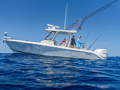 Pursuit S 288 center console boat viewed at water level with three people aboard, two men fishing and a woman seated near the helm.