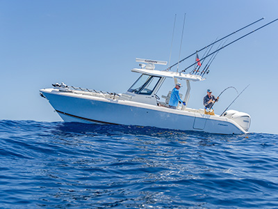Pursuit S 288 center console boat viewed at water level with two men fishing from the deck.