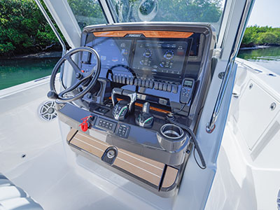 Close-up view of the Pursuit S 288 helm station from a slightly different angle, showing the Garmin displays, wood-accented dash trim, and joystick controls.