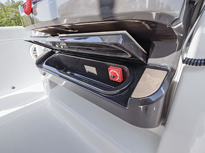 Close-up of an open electrical panel compartment on a Pursuit boat showing a red circuit breaker reset switch.