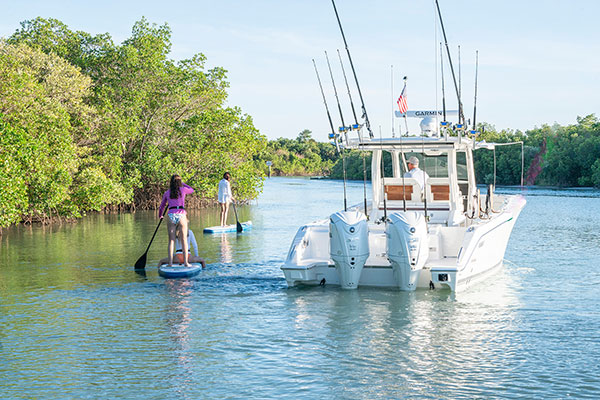 Ladies paddle boarding near a Pursuit S 328.