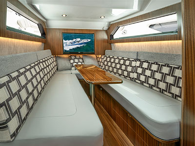 A shot of the luxurious cabin with table on the S 428 Pursuit Sport Center Console Boat.