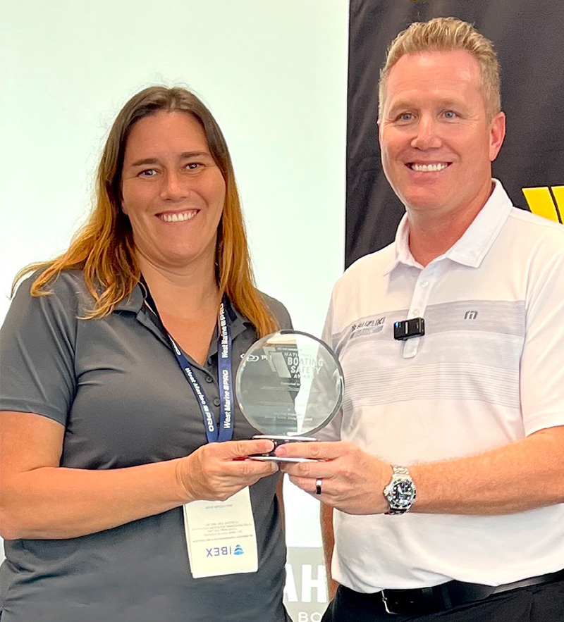 Pursuit vice president of engineering Molly Ditzler receives the award from Suzuki vice president of sales and marketing Brandon Cerka.