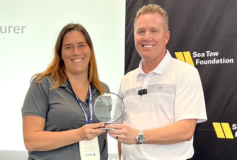 Pursuit vice president of engineering Molly Ditzler receives the award from Suzuki vice president of sales and marketing Brandon Cerka.