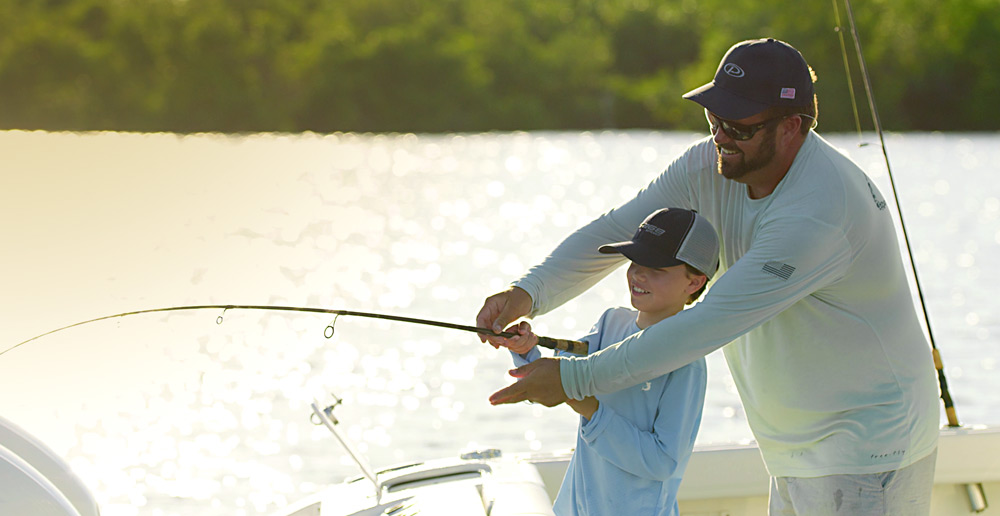 Father and son fishing from the transom of a Pursuit Boat.